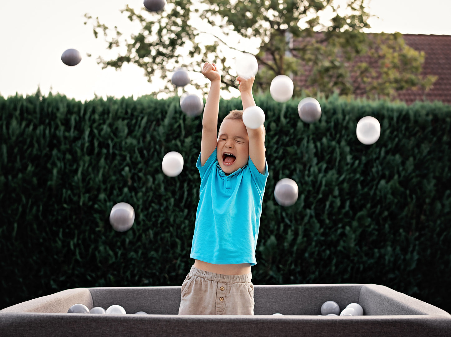 Kind spielt im grauen Bällebad 90×90×40 cm – Rainbow Kids