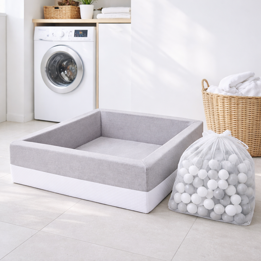 Bällebad-Bälle im Wäschenetz neben Waschmaschine – Bälle hygienisch waschen