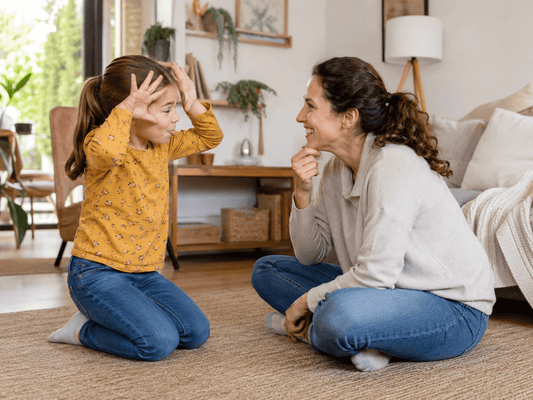 Mutter und Kind spielen zuhause Pantomime im Wohnzimmer – einfaches Spiel ohne Material für Kinder